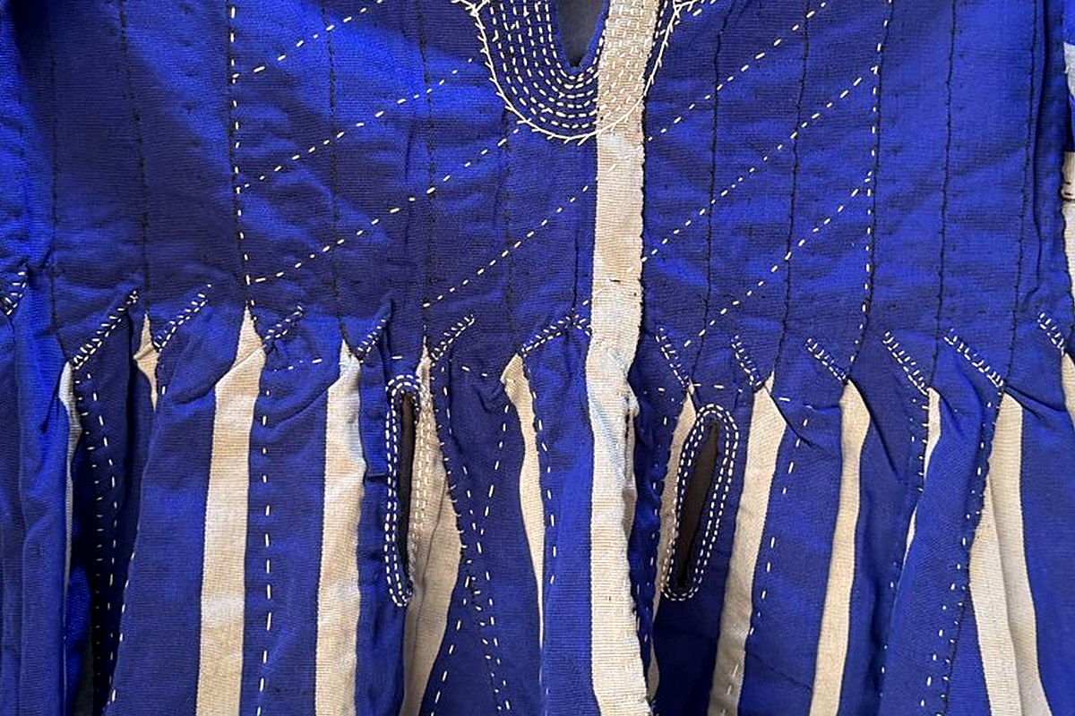Royal-blue and cream narrow-strip banding with white running-stitch on a hand-woven Blue & White fugu smock